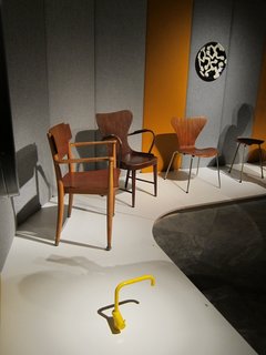 A Cherner Chair Retrospective - Photo 16 of 23 - In one corner of the show, a bright yellow Vola faucet, designed by Arne Jacobsen and Teit Weylandt in 1969, holds court with a tribe of wooden chairs from the 1940s and 50s.