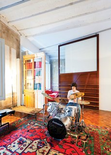 In one area of the apartment, Tagliabue’s son, Domenec, plays drums in front of a sliding wood panel of the architects’ design.