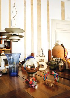 Resting atop an oak table by Miralles, amidst a collection of tchotchkes, is the "B" trophy awarded to the pair for their work on the Santa Caterina Market rehabilitation project. A Louis Poulsen lamp hangs just above.