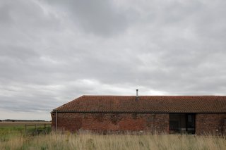 A Pair of English Barns Hide Unabashedly Bold and Budget-Friendly Minimalist Interiors - Photo 4 of 14 - Long and low, the Ochre Barn began its life as a threshing barn in the 1850s.