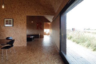 A Pair of English Barns Hide Unabashedly Bold and Budget-Friendly Minimalist Interiors - Photo 8 of 14 - At a fraction of the size of Ochre Barn, Stealth Barn is just one clear shot down the hall from the kitchen to the bedroom. OSB is an even stronger part of the interior here evoking bales of hay.