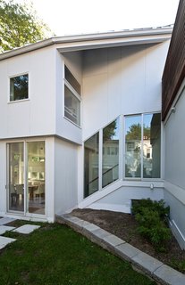 The fenestration here mimics the stairs inside. The sloping site allowed SsD Architecture to put the interior spaces on a series of floors and half floors.
