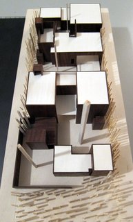 A wooden model of the house looking from the street front towards the rear alley. The house steps around major trees and offers numerous courtyards and rooftop gardens.