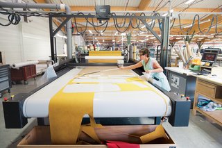 Ruché Sofa - Photo 7 of 11 - A seamstress mans the automated Gerber Cutter, which cuts patterns precisely and in a way that minimizes wasted fabric.
