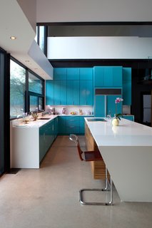 Lacquered turquoise cabinets are topped by white quartzite countertops. Photo by Brian Mihealsick.