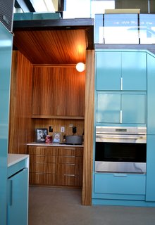 A zebrawood desk niche in the kitchen, under the steel stair landing, provides additional storage and display space. Photo by J.C. Schmeil.