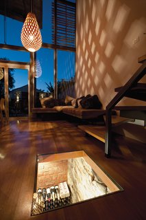 New Depths<br><br>Inspired by a local winery, George Kyprianou wanted a glass top on his subterranean wine cellar. The interior is lit, casting soft light into the living space at night and revealing the 132-year-old stone foundation. The three-quarter-inch glass lid sits flush with the floorboards; it opens with an ingenious device that Kyprianou devised using a 12-volt air compressor and a remote-controlled switch. When you push the button, the glass lifts just enough to be removed by hand.