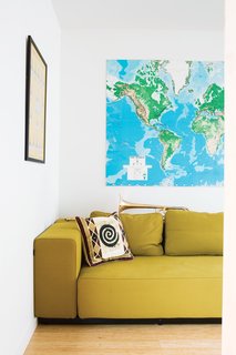A mustardy couch and a large map of the world—Whitlock travels all over the place for work—keep the living room bright and cheerful.
