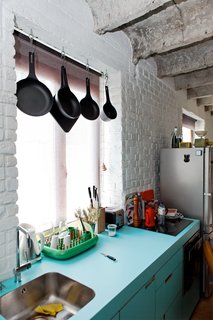 A Little Apartment Gets a Solid Renovation - Photo 5 of 8 - A green Dish Doctor by Marc Newson for Magis adds just a bit more color to the blue facing of the kitchen sink and cabinets.