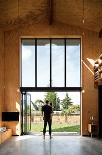 Davor and August check out the yard from the living room. "The bifold Vistalite doors allow us to open the house up completely and enjoy the fresh, warm air," Davor says.
