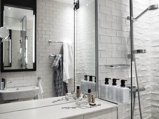 The Scandic Grand Central, Stockholm - Photo 9 of 12 - The bathrooms are crisp and uncluttered with toiletries by Face Stockholm. Scandic (like Sweden in general) has a strong environmental commitment. The bathrooms have dual-flush toilets (pretty standard in Europe), larger pump bottles rather than single-use throwaways for shampoo and soap, and a sign that says "80 percent of guests reuse towels." Nothing like the bandwagon effect to motivate people to be more conscious of the resources they use! On a related note, you have to insert your key card into a socket to turn on your room's lights. Not only does it ensure that the lights will be off when you depart, your card will always be right next to the door—great for those (such as myself) who frequently misplace small things.