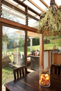 The view from the dining area extends across the lanai to the lawn, which never needs watering—it stays green from the island’s frequent rains.
