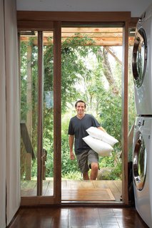 A glass slider and a stackable LG washer and dryer maximize space in the laundry area, which includes a small utility closet.