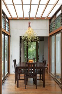 A Bright IdeaAfter build-out, the family realized they needed a light for their dining room. Tanya and Jackson took to their storage container, where they found fake flower branches they had bought at Ace Hardware, and paired them with a crumpled string of old Christmas lights. "We plugged it in and that was that," says Tanya.