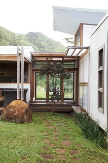 The building process was a collaborative one, with the Gambys and their architects engineering the house to meet building codes as the pieces were being installed. In the middle, a glass hallway containing the dining room connects to the kitchen.