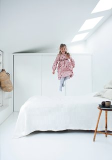 Maja demonstrates another use for the guest bed: a trampoline. Behind her is a wall of storage, an essential attribute in the 1,260-square-foot house. Extreme editing of material possessions also helps.