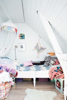 A small bed for Maja is tucked under the eaves on the other side of the photo wall.
