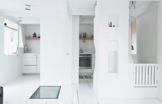 To maintain a uniform look in the kitchen, Bjerre-Poulsen secreted most of the appliances, including the fridge, behind white Kvik cabinets. He installed can lights with brass-colored interiors on the ceiling; the halogen bulbs reflect the golden interior, giving off a warm glow. Every light in the house is an overbright fixture on a dimmer, for maximum flexibility—if you can adjust different levels for every situation, from working to entertaining, then you don’t need to rely on secondary floor or table lights, Bjerre-Poulsen points out.