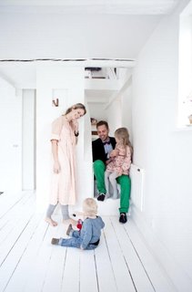 The family gathers around the staircase for a family portrait.