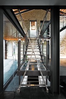 Rising to a catwalk above, a huge glass-and-steel central stair envisioned by the architect spans four floors of the Chiavellis’ newly expanded house.