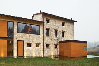 Caprioglio paired the indigenous sandstone of the existing structure with teak mounted on two-foot-wide panels. The structure at right holds the glass-topped kitchen.