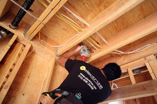 Joe Barrientos from Electrize is the electrician on the project. Here, Joe is shown drilling holes for pulling electrical wiring in the southern guest bedroom.