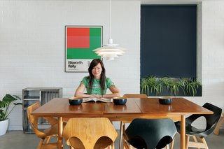 A palette of wood, concrete, and painted brick forms a neutral backdrop for Kathryn Tyler’s vintage treasures, including a $30 dining table, $3 poster, and a set of 1950s Carl Jacobs Jason chairs she snagged on eBay for $400.