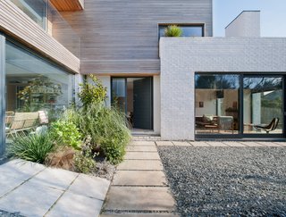 A path leads past glazing and gravel to the front door.