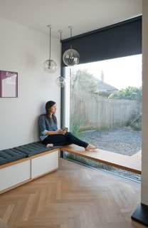 A built-in bench by the window is a cozy perch for Tyler. The herringbone flooring is engineered oak.