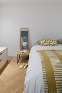 A peek inside the master bedroom, with touches of marigold yellow throughout.