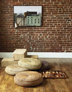 In the office, a vintage brass gooseneck floor lamp positioned above woven jute cushions creates the perfect perch for Mandayam’s backgammon hobby. The painting—Wall, from 2002—is by Nicholas Evans-Cato, a professor at RISD.