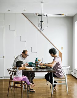 At right, the family dines at a mid-century walnut table found on eBay, seated at a mix of new and antique Wishbone chairs by Hans Wegner.