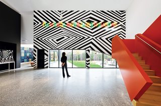 Anchoring the Housemuseum’s music room is the mural YOU’VEALWAYSWANTEDTOBEBLACK (white friend), a 2006 piece by artist Brook Andrew. The red staircase leads to the bedrooms and additional gallery space on the second floor.