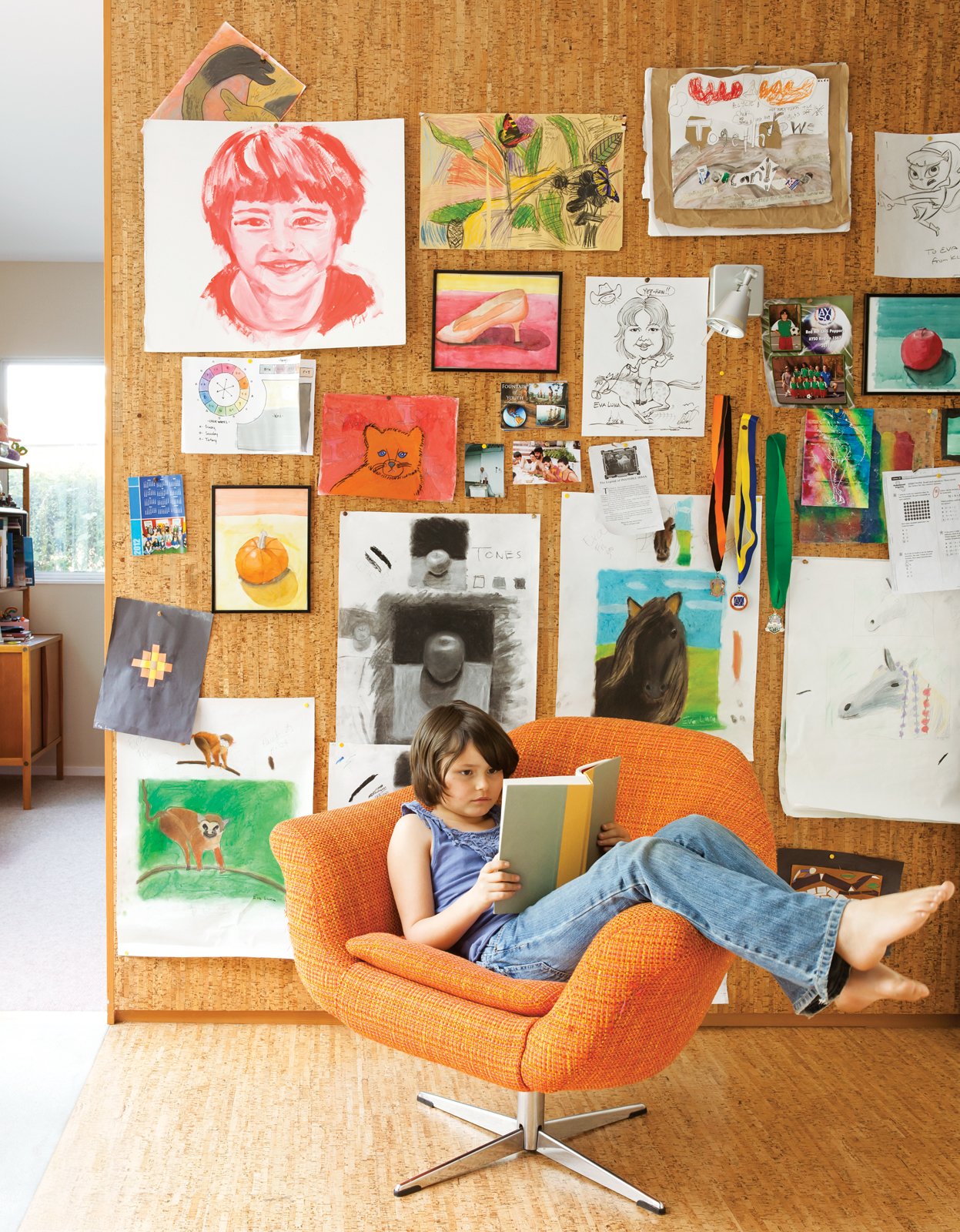 The pair’s art covers a cork wall where Eva Luna reads in a vintage Danish lounge chair.