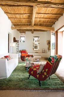 10 Modern Renovations to Homes in Spain - Photo 4 of 10 - In Marquina and Font’s living room, a pair of kilim-covered chairs by Philippe Xerri, a chest of drawers by Piet Hein Eek, and a handmade Tunisian rug provide bursts of color amidst the overall scheme of white, ecru, and cream.
