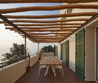 On the patio, robinia wood beams shade a Kettal Vieques dining table and set of Moroso Supernatural chairs.