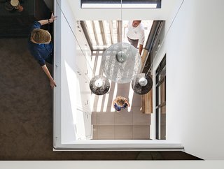 Inside, just off the entrance, pendant lights from Woonfabriek hang in the triple-height central hall.