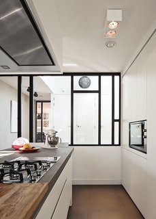 With a custom design by Scalo, the kitchen is "white and simple; we didn’t want handles," notes De Graaf. The hotplate, oven, and teppan-yaki grill are from Falliss.