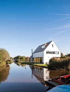 The newly built house, just feet from the water’s edge, occupies the space where a decaying farmhouse once stood.