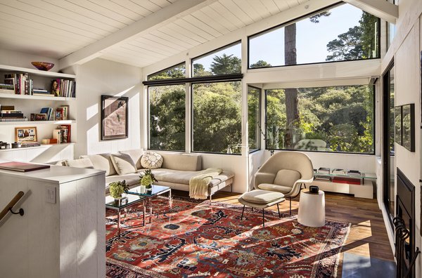 Schicketanz whitewashed the living room’s wood walls and replaced the carpet with teak flooring reclaimed from elsewhere on site. Workers also dismantled the dark stone fireplace to widen the view, installing an efficient, compact fireplace on the southern wall. “From sunrise to sundown, you have light in the house,” Schicketanz says. “It’s bright even on gloomy days.” Photo 3 of Torres House modern home