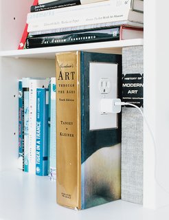 Renovated Garage is the Ultimate Modern Party Space - Photo 3 of 9 - The garage is an exercise in "hide and reveal." The Corian shelf features an outlet in a converted book, a detail that brings delight to a mundane task. "We wanted to make the experience of plugging in a phone or computer joyful," Grizzle says.