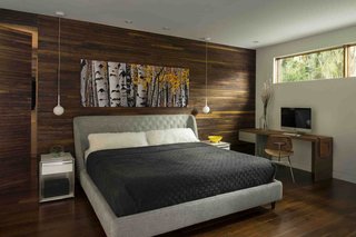 Wood was used more extensively in the master bedroom. "I think the intention was just to warm it up and make it more cozy," Kean says. A wood-covered "disappearing door" cleverly conceals a closet.