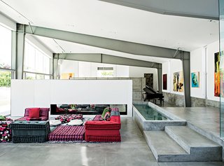A Mah Jong sofa by Roche Bobois in the living room lends a colorful counterpoint to the custom water feature that runs alongside it.