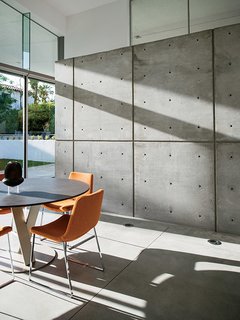 In a dining area, Metropolitan chairs from B&B Italia provide seating at a circular Syntaxe table from Roche Bobois.