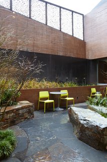Commons' Grounds - Photo 2 of 9 - The landscaped courtyard—which features seating, tables, and a bioswale—provides a sheltered place for people to wait for services. Photo by Chris Mueller.