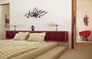 A McKenzie-designed bed and a retro wall-hanging in one bedroom.
