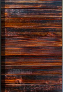 The charred wood siding, inspired by the Japanese shou-sugi-ban method, comes in various stains, such as cherry (shown here). The blow-torching technique helps with resistance to insects, rot, water, mold and fire.