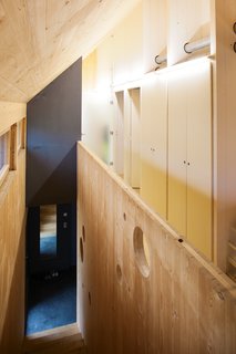Dividing Line<br><br>The home’s central "spine," which <br><br>Witzmann describes as "the back-<br><br>bone of the house at a load-bearing <br><br>and technical level," serves as the <br><br>structure’s organizing principle. It <br><br>groups the ventilation system and the <br><br>majority of the electrical networks <br><br>together and centralizes much of the <br><br>home’s storage. By siting the living <br><br>spaces on the south of the house <br><br>so that they take advantage of the <br><br>natural light, and placing the sanitary <br><br>and service rooms on the north, the <br><br>architects make the most of a smart <br><br>passive solar layout.