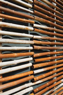 All told, they hung some 28,000 linear feet of the material with the larger sections composed of around 250 stalks. Each pole is threaded with <br><br>galvanized steel wire and separated from the next by a small aluminum spacer. A highly renewable resource, the untreated bamboo has aged over <br><br>time; what started as yellow-green has turned into a muted gray just a year after completion.