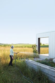 Maggie Treanor waters plants around her rural home.